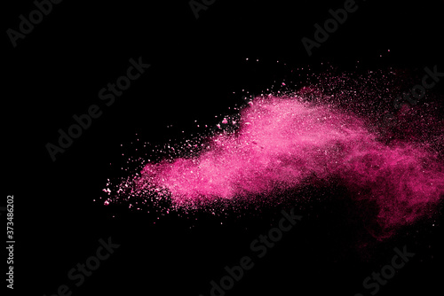 Pink powder explosion on black background. Paint Holi.