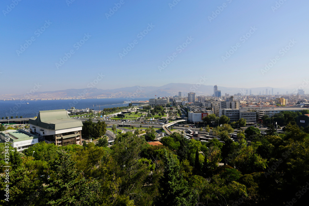 Aerial view of Aegean sea and Konak district, busiest area of the coastal city of Izmir, Turkey, in a photo taken from Varyant neighborhood during a hot summer day.