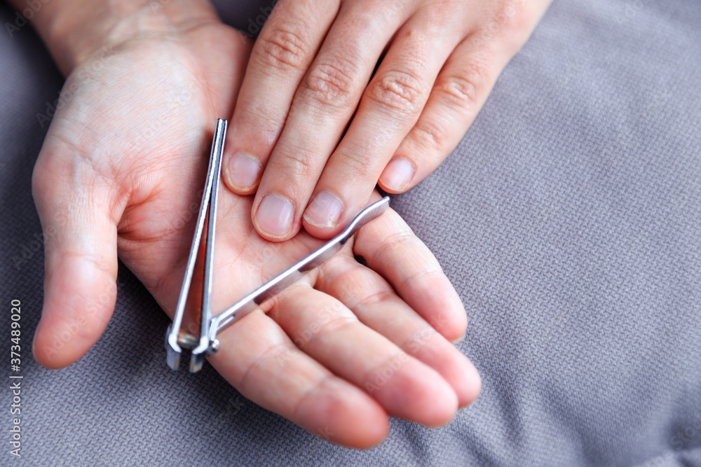 Man cutting nails using nail clipper. Nail clipper in the hands of a man Man cutting nails using nail clipper. Nail clipper in the hands of a man