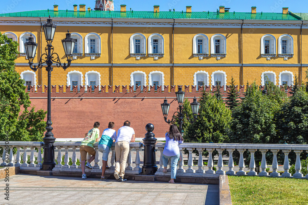 Obraz premium Tourists leaned on the railing and look at the Alexander garden and the Kremlin wall
