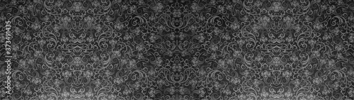 Old black anthracite gray vintage worn shabby seamless square patchwork tiles stone concrete cement wall texture wide background banner panorama wallpaper, with flower leaves print