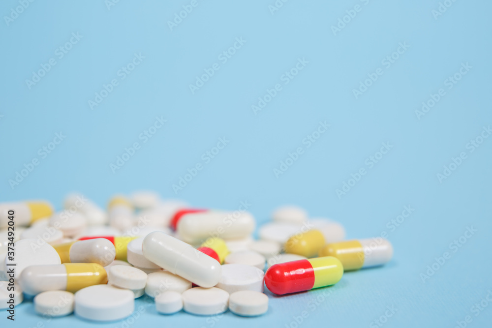 Pills are scattered over a blue background Pills are scattered over a blue background