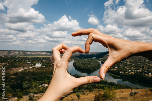 Hands in a shape of heart with a view over Drienster river, Moldova.