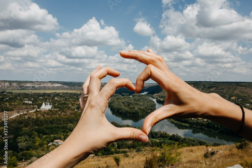 Hands in a shape of heart with a view over Drienster river.
