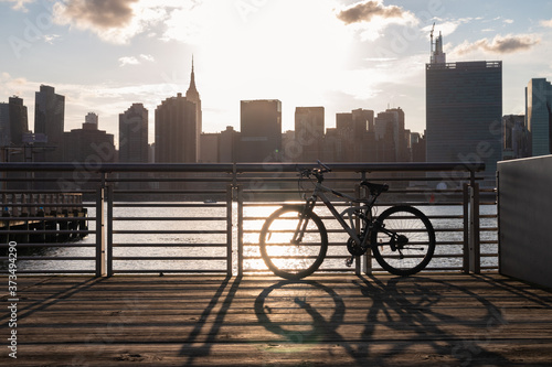 Bicycle on a Railing along the East River at Gantry Plaza State Park in Long Island City Queens during a Sunset with the Manhattan Skyline © James