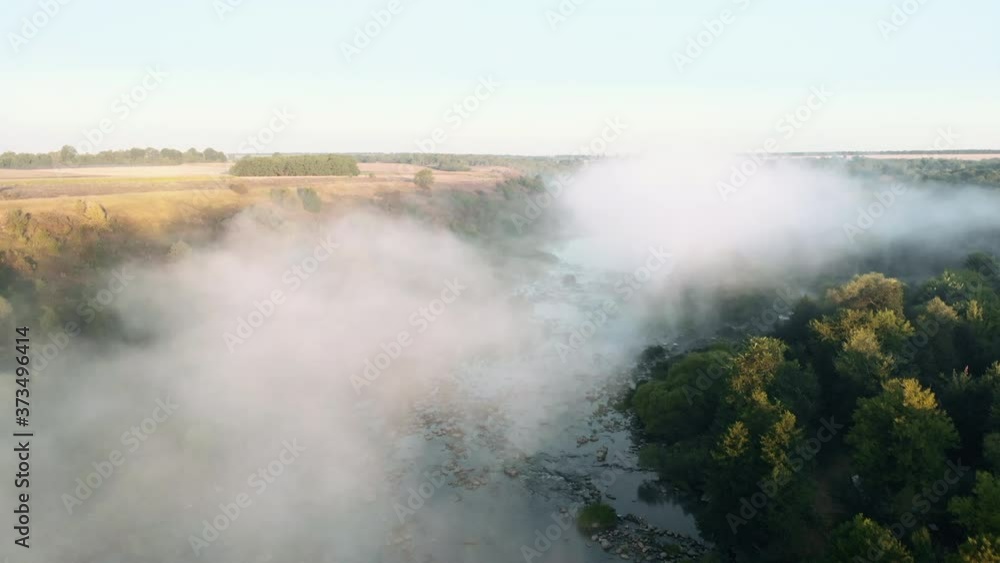 Morning river with rapids. Flying the copter through the morning fog over the river. View from the drone to the misty river. River rapids foggy. Forest river flow. Morning river with rapids. Flying the copter through the morning fog over the river. View from the drone to the misty river. River rapids foggy. Forest river flow.