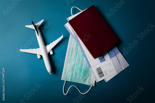 travel during the covid-19 pandemic. airplane model with face mask and travel documents