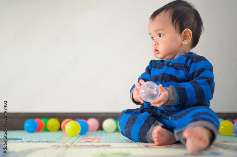 Obraz premium Kid playing with ball on soft carpet in children room