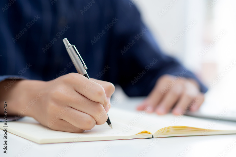 Closeup hand of man writing on notebook with pen on desk, freelance is author, businessman write on notepad on table, book, letter and report, finance and document, business or education concept. Closeup hand of man writing on notebook with pen on desk, freelance is author, businessman write on notepad on table, book, letter and report, finance and document, business or education concept.
