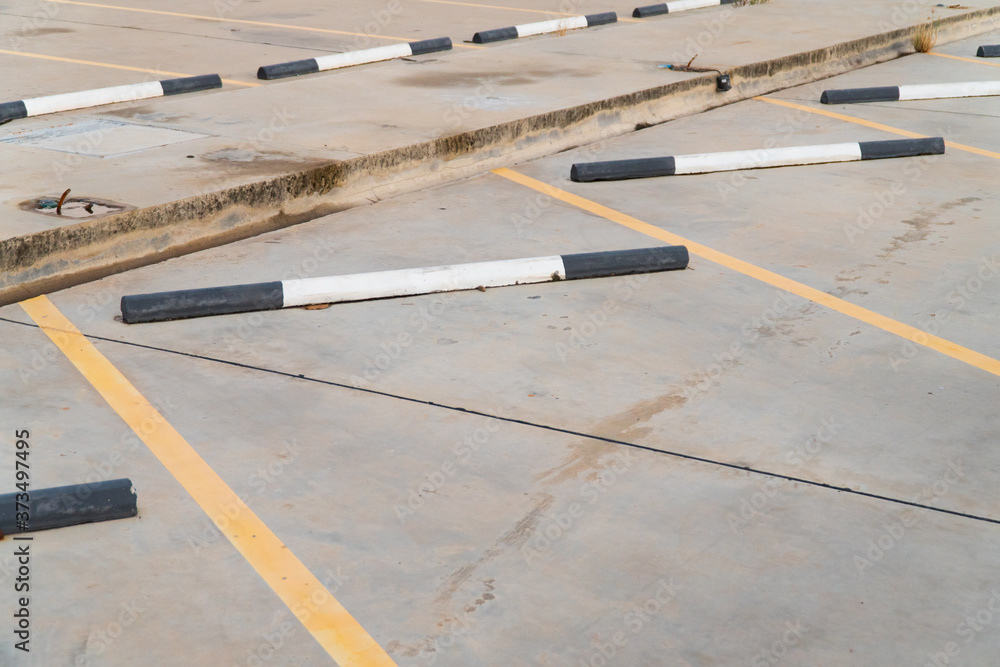 Empty car parking lot with black and white concrete car stopper and yellow line. Empty car parking lot with black and white concrete car stopper and yellow line.