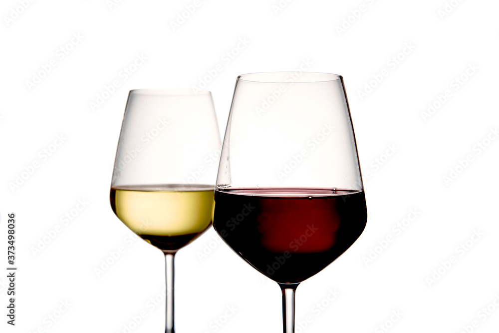 Foreground of two glasses of wine, the first is a glass of red wine, the second is a glass of white wine on a light background Foreground of two glasses of wine, the first is a glass of red wine, the second is a glass of white wine on a light background