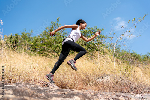 Young Black Woman Running and Jumping at Forest Trail.