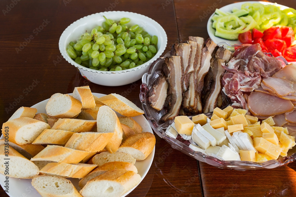 Bread, meat cuts, cheese, grapes on the snack table Bread, meat cuts, cheese, grapes on the snack table