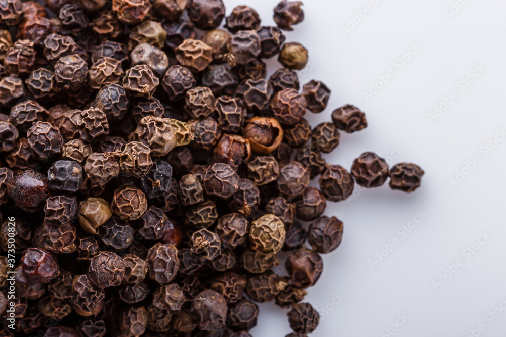 Fototapeta premium fragrant black pepper on white acrylic background