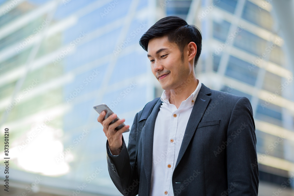 A young confident businessman using smartphone in the city. A young confident businessman using smartphone in the city.