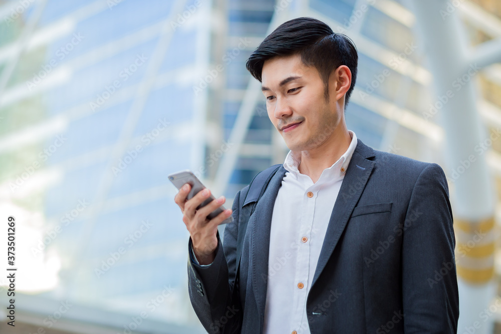 A young confident businessman using smartphone in the city. A young confident businessman using smartphone in the city.