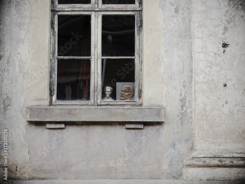 A portrait of Lenin and a bust of Dzerzhinsky outside the window of the apartment.