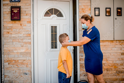 Wallpaper Mural Woman helping her son to be ready to go back to school. They are  wearing a protective face mask  Torontodigital.ca
