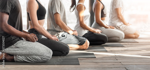 Wellness Concept. Side View Of Diverse People Meditating Together During Yoga Class