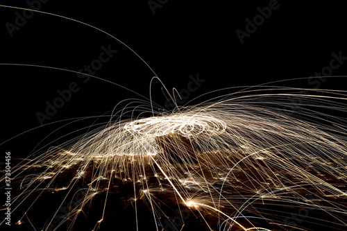 A steel wool on fire at night  night photography using a slow shutter speed  - selective focused on the subject.