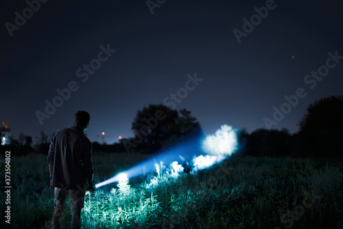 Person with flashlight at night photo