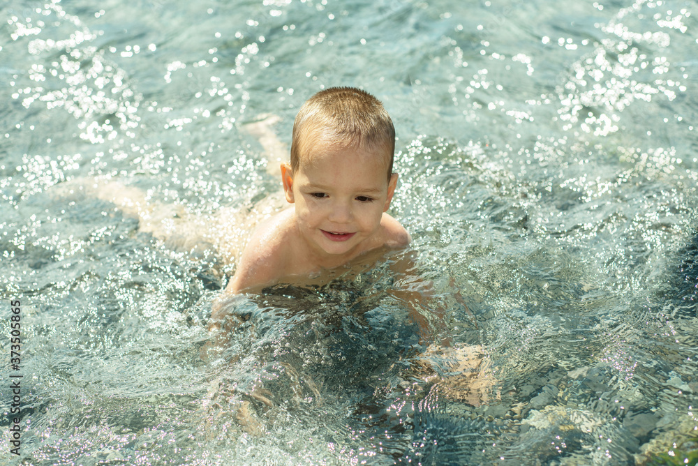Baby boy swimming in the sea, summer holidays