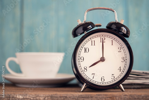 Retro alarm clock on wooden table, vintage style