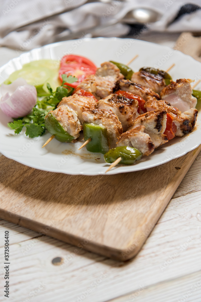 Appetizer kebabs in skewers in a plate on a wooden board