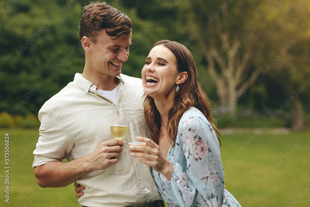 Beautiful couple in love with champagne at park Beautiful couple in love with champagne at park
