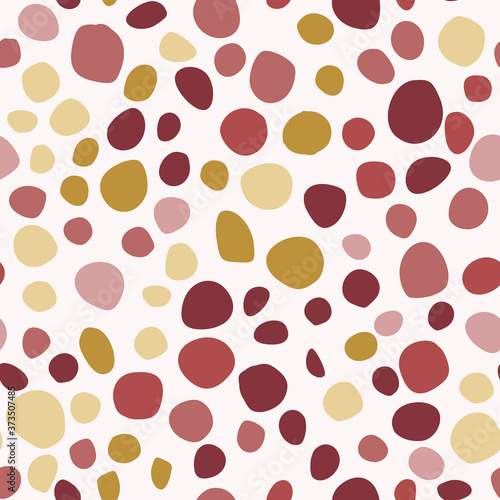 Seamless isolated circle spot geometric pattern. Red, maroon, yellow, ocher color shapes on white background.