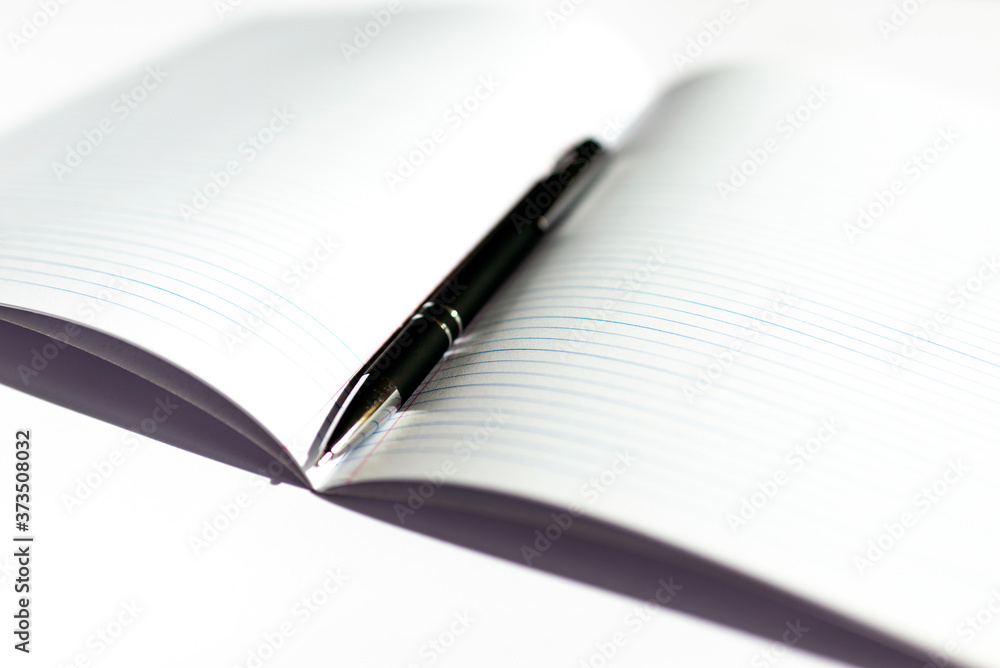 Top view of opened notepad with black pen white background. Mockup for your banner. Flat lay. Top view of opened notepad with black pen white background. Mockup for your banner. Flat lay.