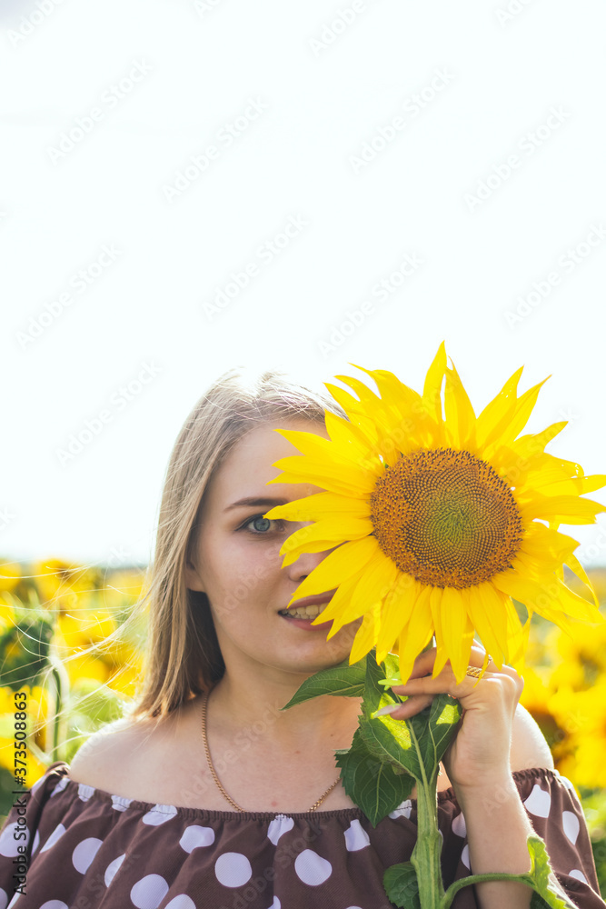 Woman in dress with polka dots on a field of sunflowers. Close plan. Woman in dress with polka dots on a field of sunflowers. Close plan.