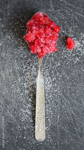 Teaspoon with fresh red currants, mixed with sugar
