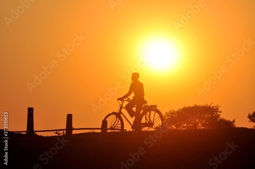 Silhouette of a cyclist at dusk.