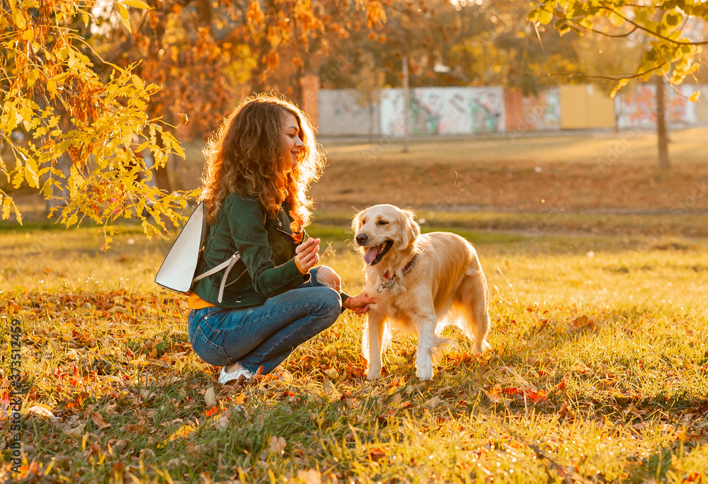 Happy woman rest with her dog golden retriever. Female athlete enjoying outdoor with her pet. woman is training outside during season time