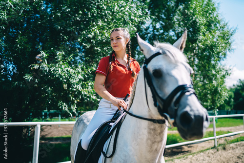 Female equestrian on back of white horse