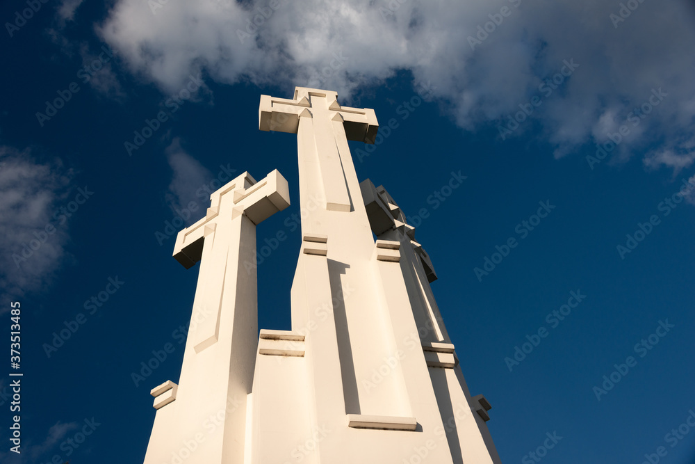 The Three Crosses monument overlooking Vilnius Old Town on sunset. Vilnius landscape from the Hill of Three Crosses, located in Kalnai Park, Lithuania. The Three Crosses monument overlooking Vilnius Old Town on sunset. Vilnius landscape from the Hill of Three Crosses, located in Kalnai Park, Lithuania.