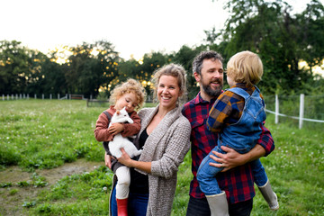 Portrait of family with small children standing on farm, resting.
