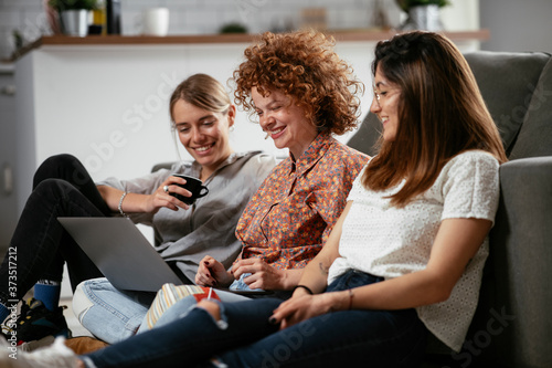 Happy businesswomen talking and laughing in office. Beautiful women on coffee break.. © JustLife