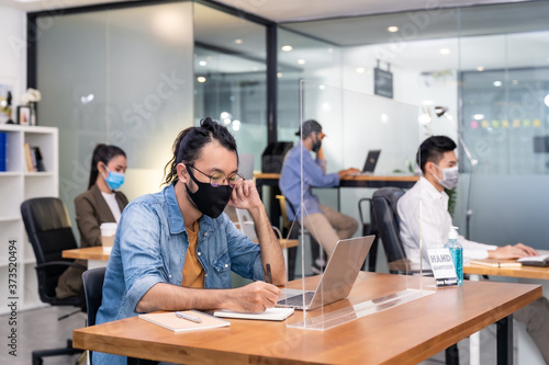 Social distance office with business team wear face mask as new normal life