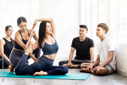 Asian Yoga coach tarining to yoga student