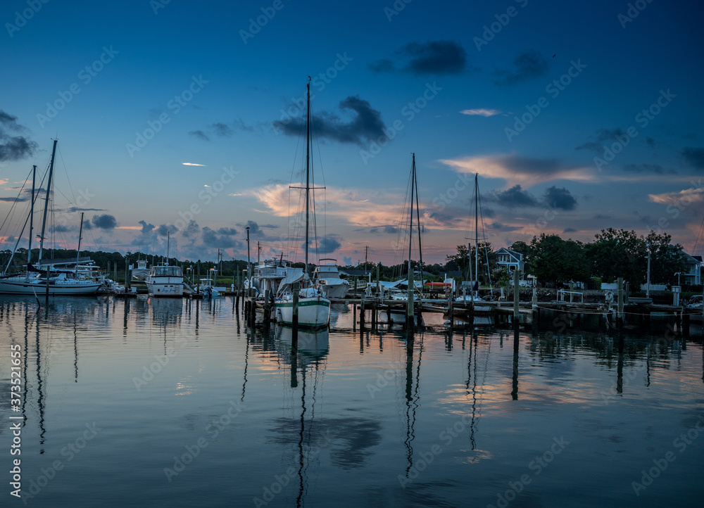 Predawn at the dock with sailboats on calm waters