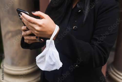 Midsection of businesswoman text messaging on smartphone photo