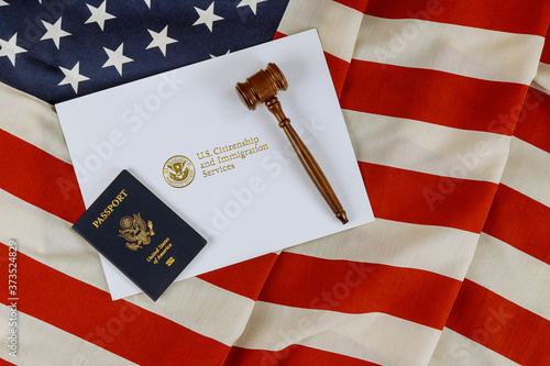US Passports with wooden judge gavel on American flag on legal world immigration concepts a citizenship
