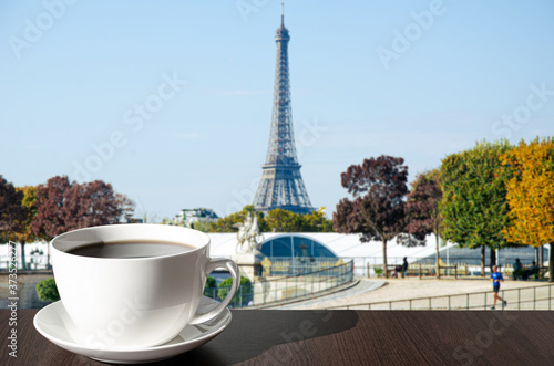 Cup of coffee on the table with view of Eiffel tower in autumn in Paris, France © Maria Vonotna
