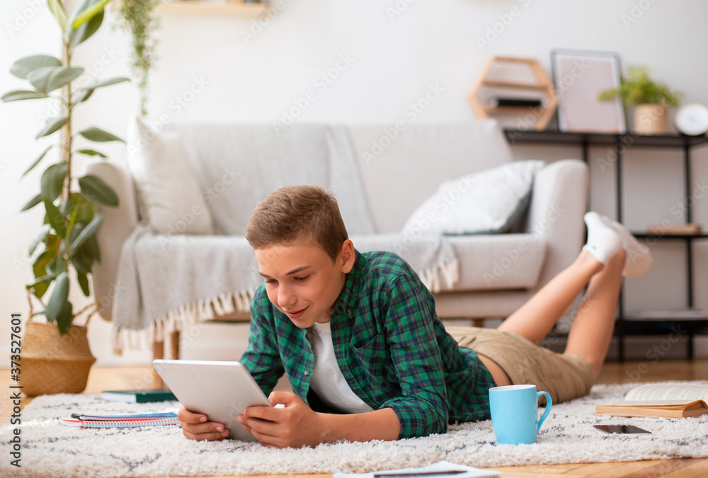 Schooler using digital tablet while studying at home Schooler using digital tablet while studying at home