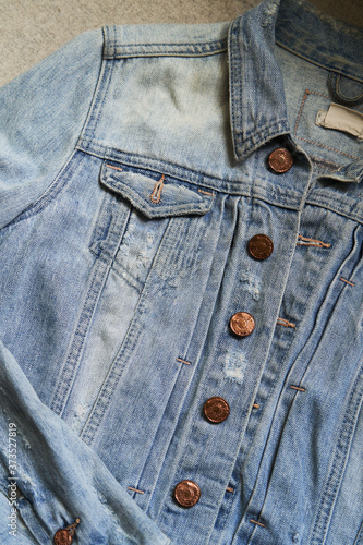 Close up view of denim jacket with buttons and pocket.