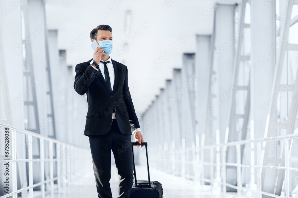 Successful businessman going by airport, talking on phone Successful businessman going by airport, talking on phone