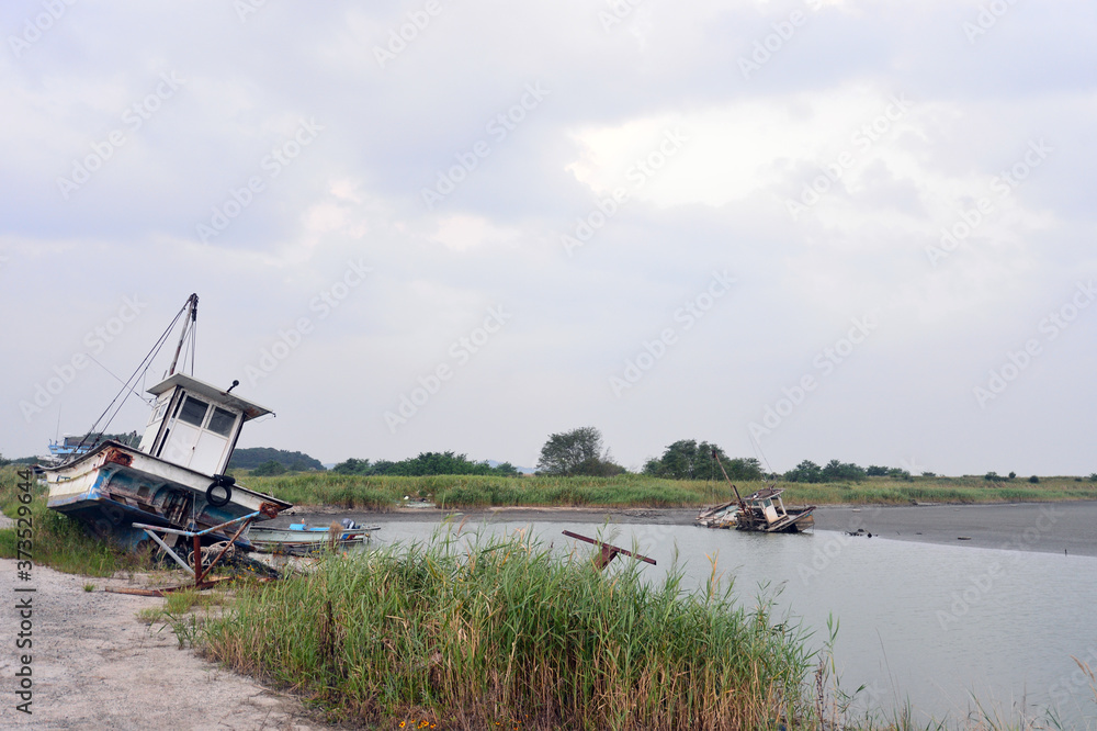 Fototapeta premium Scrapped Fishing boats at Haje Port closed by the Saemangeum seawall in Okseo-myeon, Gunsan, North Jeolla Province, South Korea on the evening of August 24, 2020.
