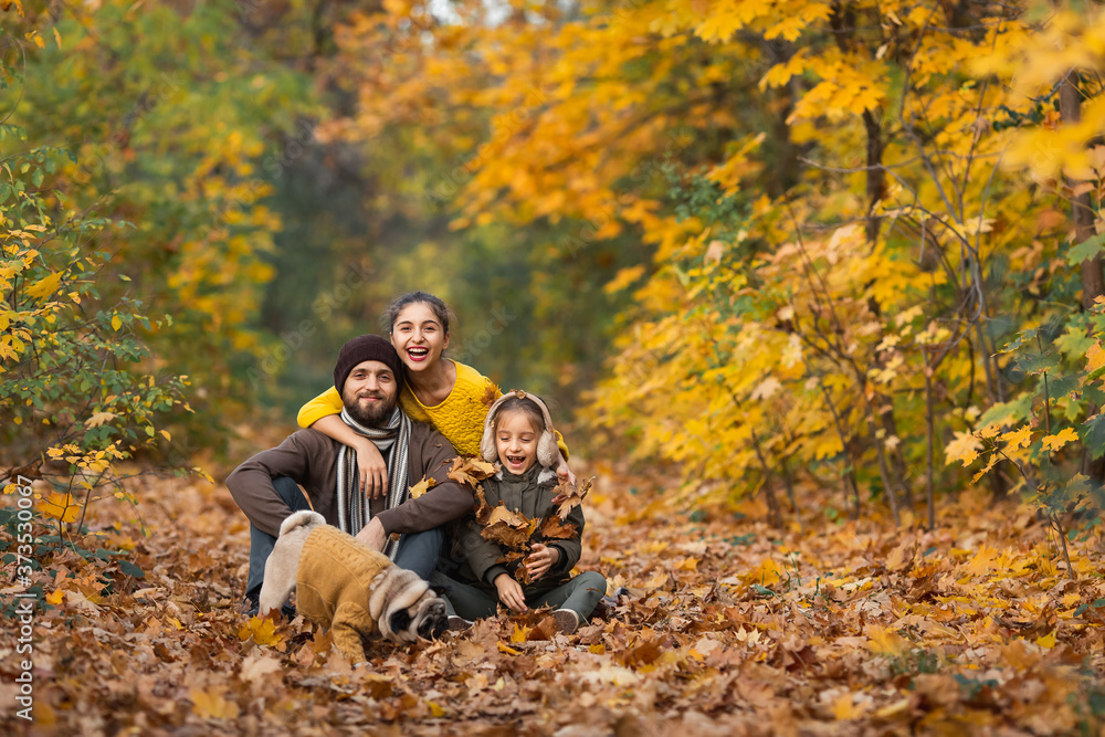 bearded dad with daughters and a dog in the leaves in autumn in the park bearded dad with daughters and a dog in the leaves in autumn in the park